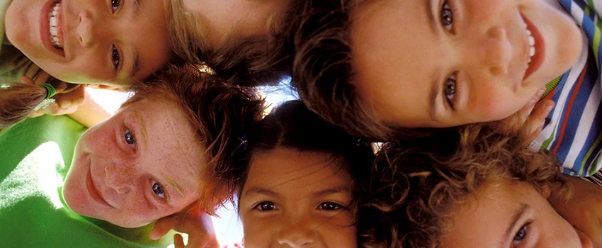 looking up into the eyes of group of children in a huddle